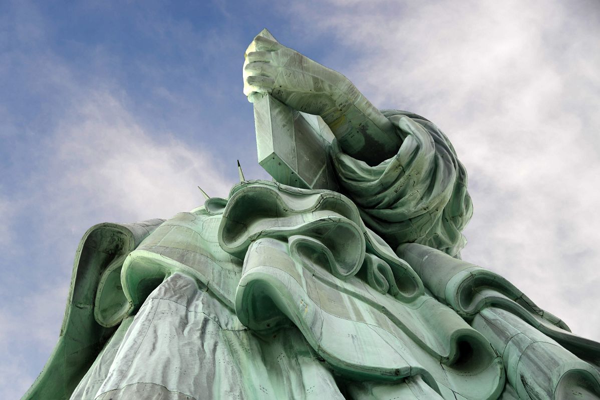 07-03 Statue Of Liberty Side View Of Her Enormous Hand Holding A Book With Folds Of Her Clothing From Pedestal